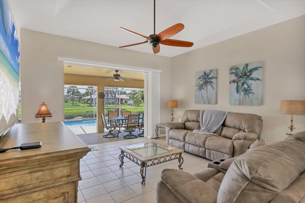 Living room overlooking pool. Living room features plenty of comfy seating and 75-inch Smart TV