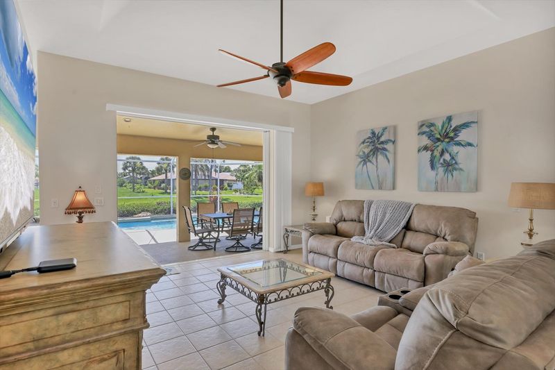 Living room overlooking pool. Living room features plenty of comfy seating and 75-inch Smart TV