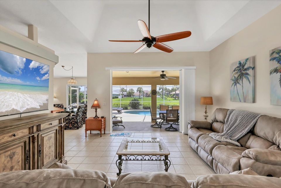 Living room overlooking pool. Living room features plenty of comfy seating and 75-inch Smart TV
