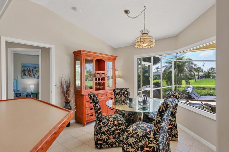 Kitchen knook overlooking the sparkling pool. Table seats 4