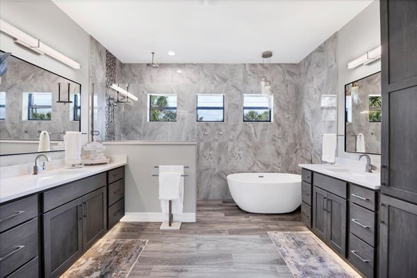 Primary bedroom's attached bathroom with large walk-in shower, double vanities and a relaxing soaking tub