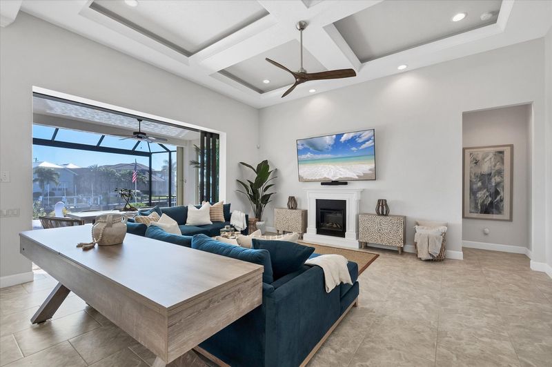 Beautiful, bright, open living space. Living room features ample seating, shuffleboard table, electric fireplace, lanai access, and huge 84-inch Smart TV