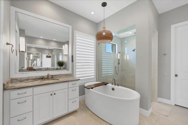 Primary attached bathroom with walk-in shower, soaking tub, and double vanities
