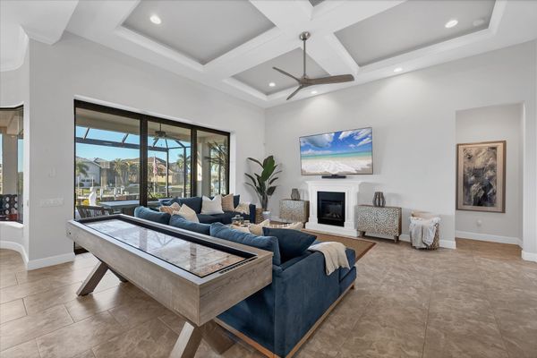 Beautiful, bright, open living space. Living room features ample seating, shuffleboard table, electric fireplace, lanai access, and huge 84-inch Smart TV