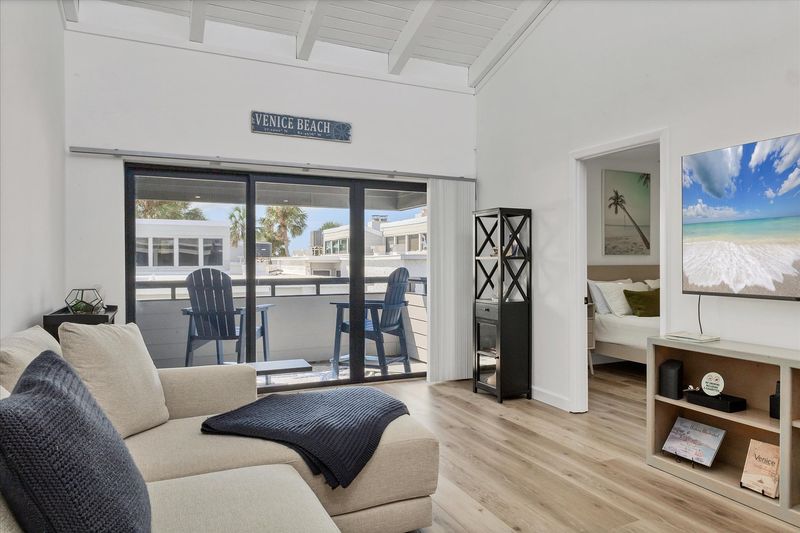 Bright, open living/dining space. Living room features comfy seating, a 65-inch Smart TV and balcony access