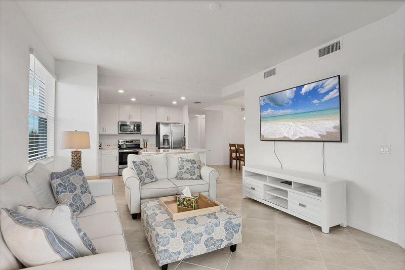 Bright, open living space. Living room overlooks the nature preserve and features ample seating and 65-inch Smart TV