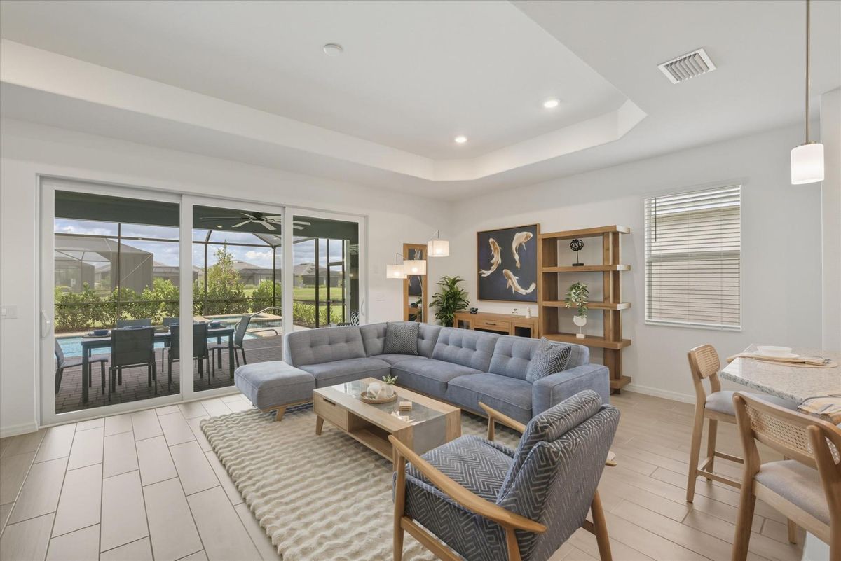 Living room overlooking the sparkling pool. Features ample seating and 85-inch Smart TV