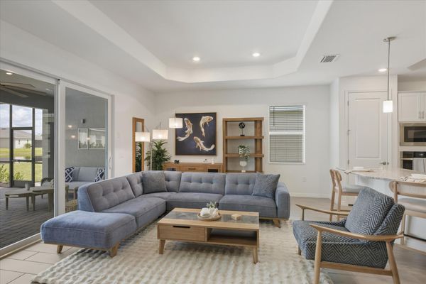 Living room overlooking the sparkling pool. Features ample seating and 85-inch Smart TV