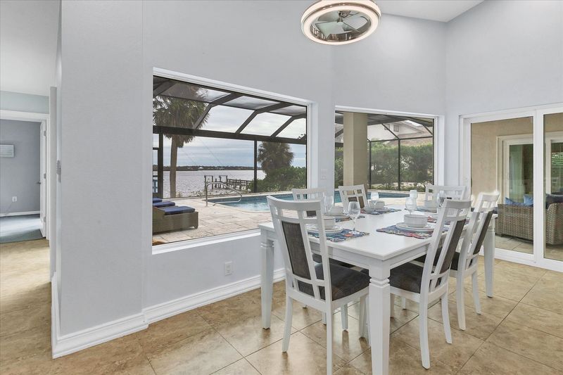 Dining area with water view. Dining table seats six, with additional seating for four at the kitchen island