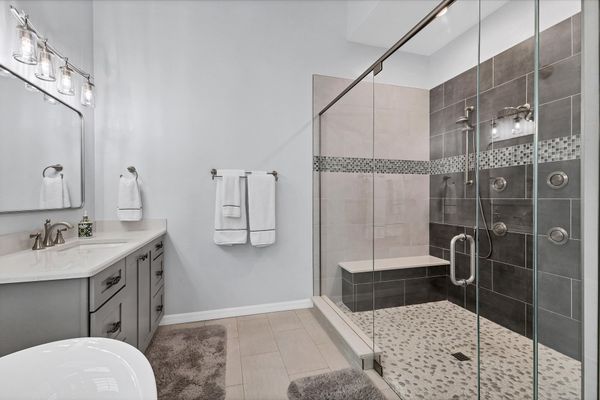Primary en suite with large walk-in shower, soaking tub, and double vanities