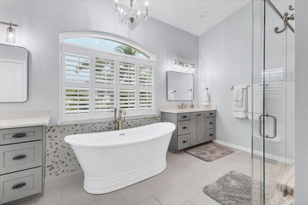 Primary en suite with large walk-in shower, soaking tub, and double vanities