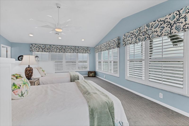 Upstairs guest bedroom features two queen beds, 50-inch Smart TV, attached bathroom, and 160 degree view of Lemon Bay