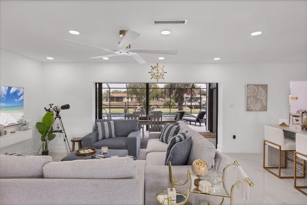 Living room overlooking the pool & canal. Living features ample & comfy seating, and 65-inch Smart TV