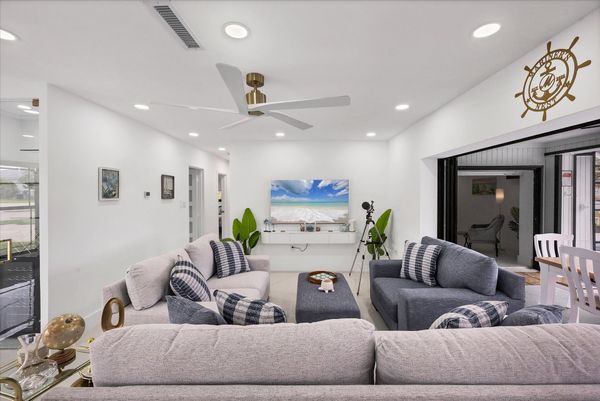 Living room overlooking the pool & canal. Living features ample & comfy seating, and 65-inch Smart TV