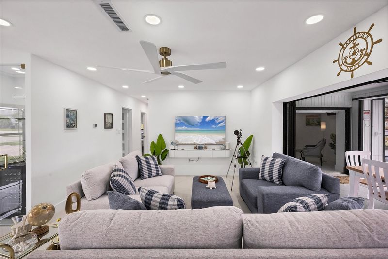 Living room overlooking the pool & canal. Living features ample & comfy seating, and 65-inch Smart TV