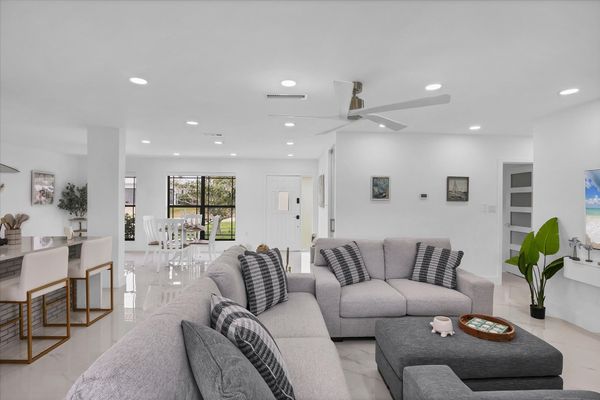 Living room overlooking the pool & canal. Living features ample & comfy seating, and 65-inch Smart TV