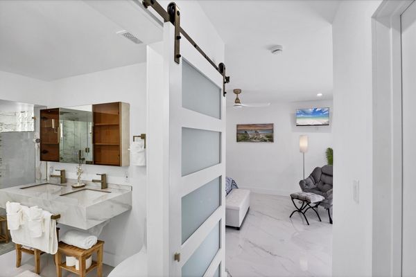 Double suite attached bathroom with walk-in shower, soaking tub, and double vanities