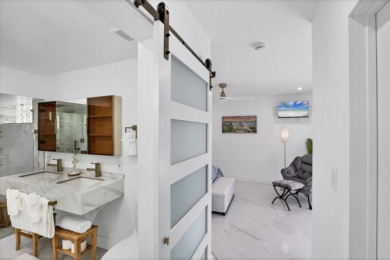Double suite attached bathroom with walk-in shower, soaking tub, and double vanities
