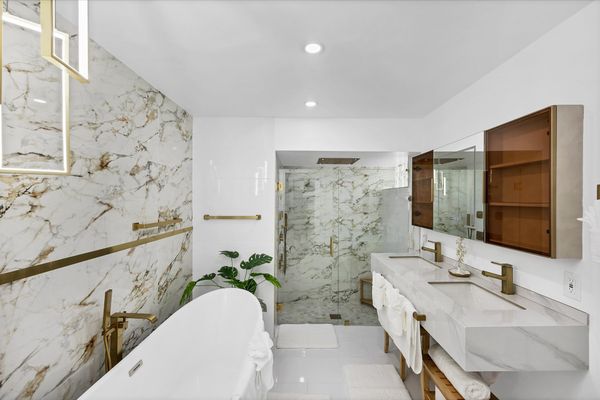 Double suite attached bathroom with walk-in shower, soaking tub, and double vanities