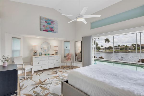 Primary bedroom with gorgeous water view, queen bed, attached bathroom and lanai access