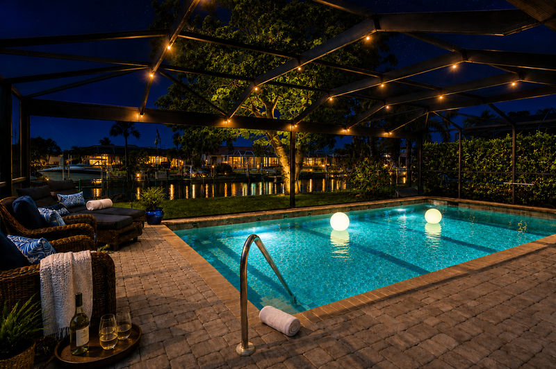 Large outdoor living space with dining table that seats 4, sun loungers, BBQ grill, sparkling pool, and 40-inch Smart TV