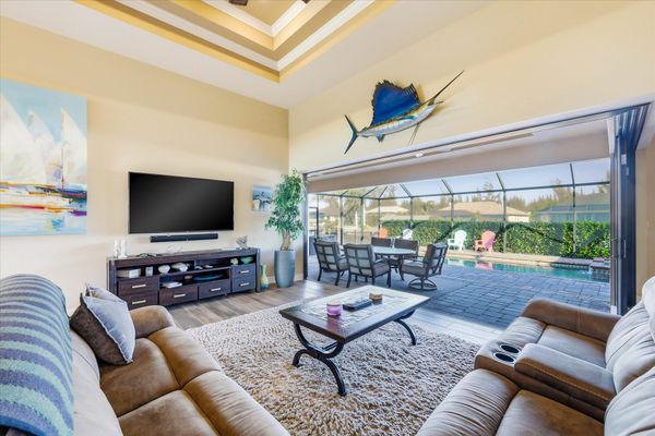 Living room overlooking the pool with comfy seating and 70-inch Smart TV