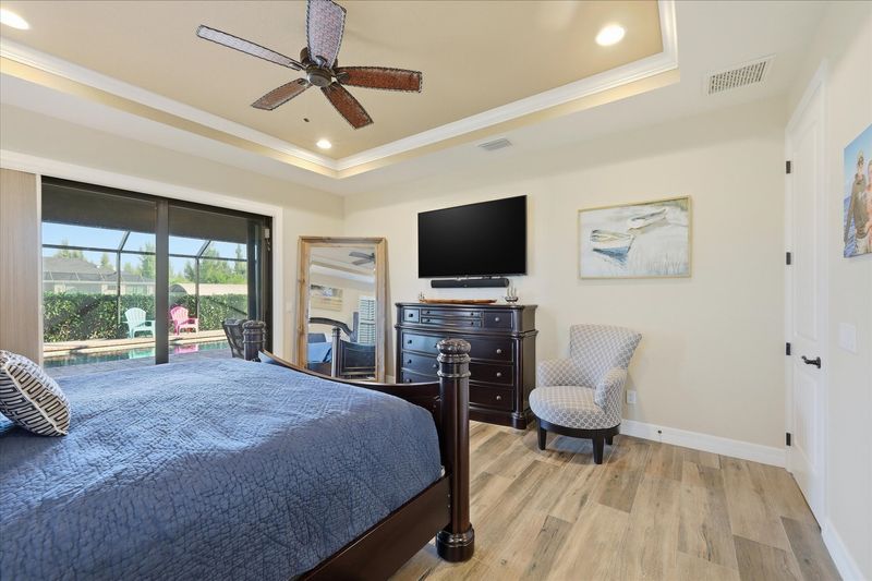 Primary bedroom with king bed, en suite, lanai accress, and 65-inch Smart TV