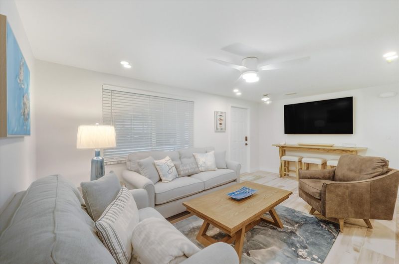 Living room featuring lots of comfy seating and 65-inch Smart TV