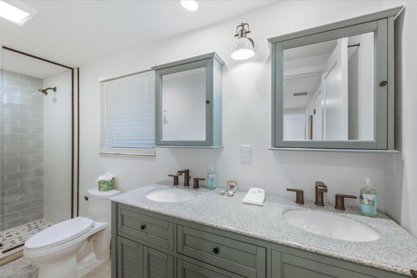 Bedroom 1's attached bathroom with walk-in shower and double vanities