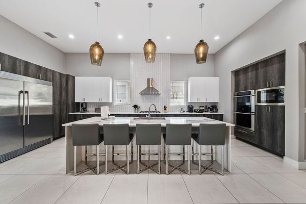 The kitchen has stainless steel appliances and a double door commercial refrigeratorThe breakfast bar has seating for up to 5 guests