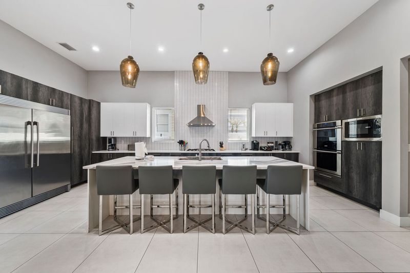 The kitchen has stainless steel appliances and a double door commercial refrigeratorThe breakfast bar has seating for up to 5 guests