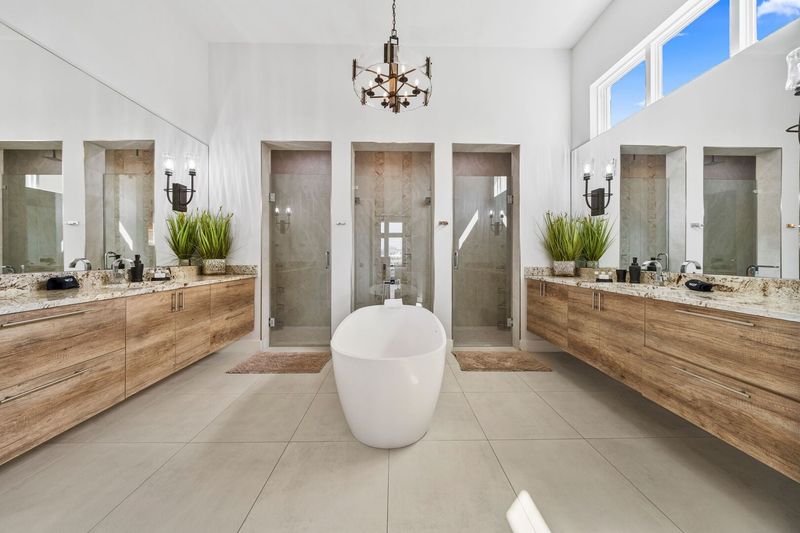 The ensuite bathroom has a beautiful garden tub and his and her showers