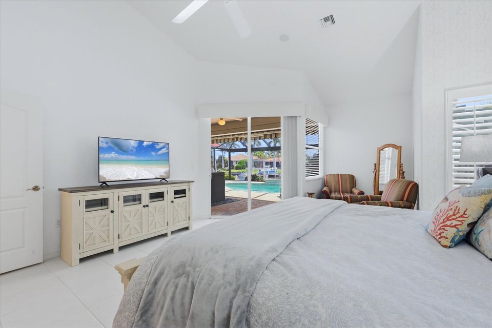 Primary bedroom with king bed, attached bathroom, lanai access, and 50-inch Smart TV