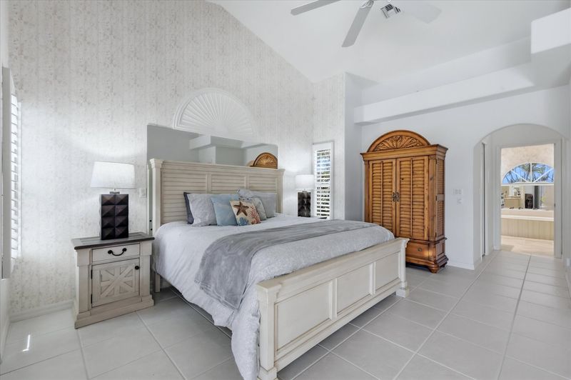 Primary bedroom with king bed, attached bathroom, lanai access, and 50-inch Smart TV
