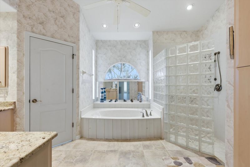 Primary bedroom's attached bathroom with walk-in shower, garden tub, and double vanities