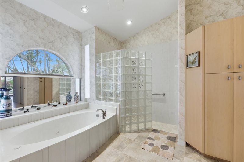 Primary bedroom's attached bathroom with walk-in shower, garden tub, and double vanities