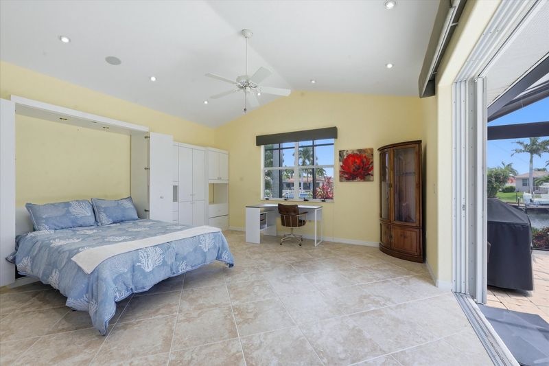 Bedroom 2 with queen Murphy bed, lanai access, and desk & chair