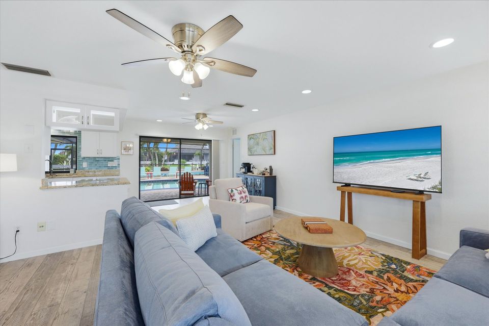 Living room overlooking the pool. Living room features lots of comfy seating, a ready nook, and 85-inch Smart TV