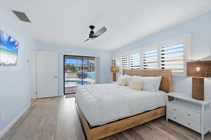 Bedroom 1 - Primary bedroom with king bed, attached bathroom, lanai access, and 43-inch Smart TV