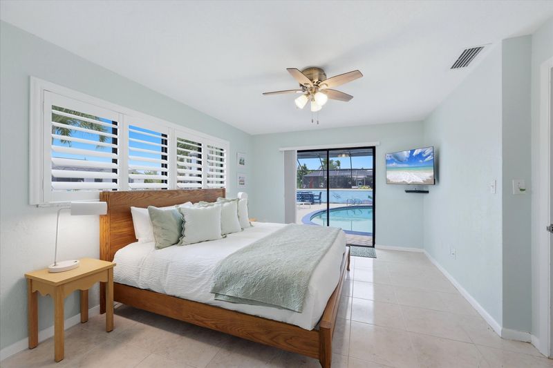 Bedroom 2 with king bed, attached bathroom, lanai access, and 43-inch Smart TV