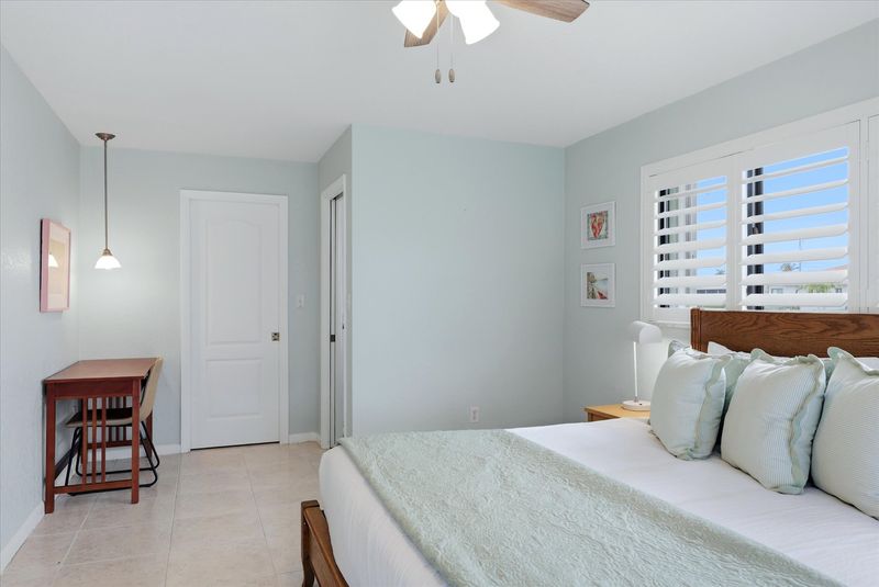 Bedroom 2 with king bed, attached bathroom, lanai access, and 43-inch Smart TV
