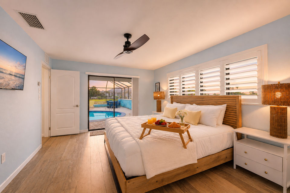 Bedroom 1 - Primary bedroom with king bed, attached bathroom, lanai access, and 43-inch Smart TV