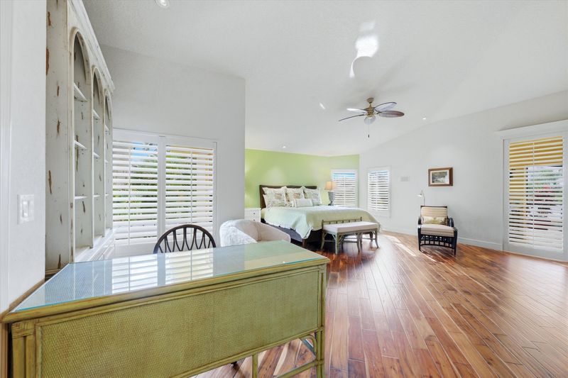 Huge primary bedroom with king bed, lanai acces, attached bathroom, desk & chair, and 55-inch Smart TV