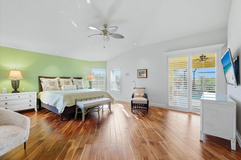 Huge primary bedroom with king bed, lanai acces, attached bathroom, desk & chair, and 55-inch Smart TV