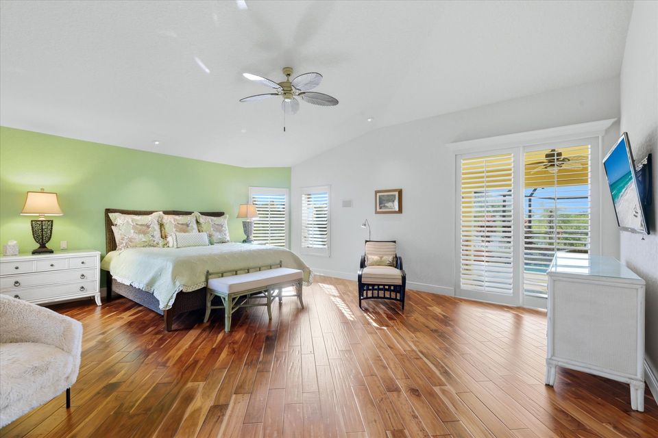 Huge primary bedroom with king bed, lanai acces, attached bathroom, desk & chair, and 55-inch Smart TV