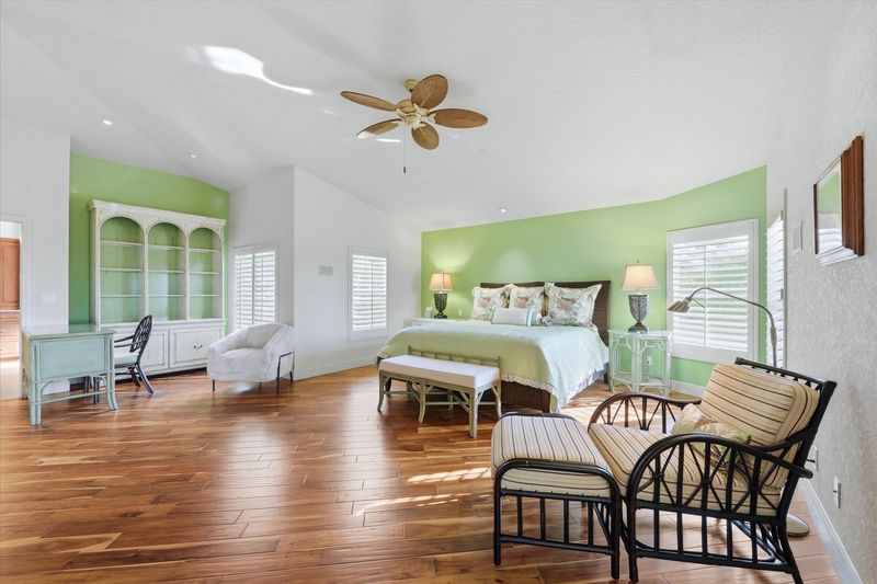 Huge primary bedroom with king bed, lanai acces, attached bathroom, desk & chair, and 55-inch Smart TV
