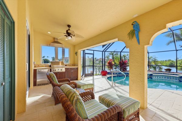 Large outdoor living space overlooking the sparkling pool & spa, and the canal beyond. Space also features out door furniture, a dining table that seats 4, outdoor kitchen with grill & fridge, ans sun loungers. Pool size: 28' x 8' x 6'D