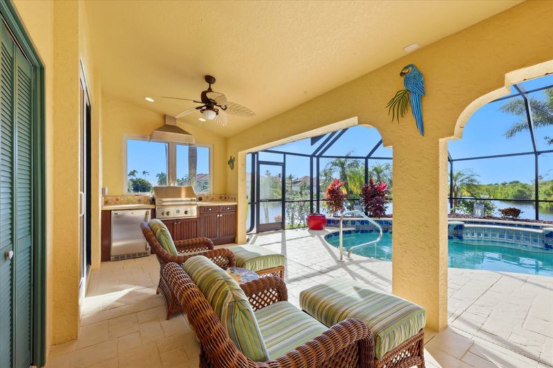 Large outdoor living space overlooking the sparkling pool & spa, and the canal beyond. Space also features out door furniture, a dining table that seats 4, outdoor kitchen with grill & fridge, ans sun loungers. Pool size: 28' x 8' x 6'D