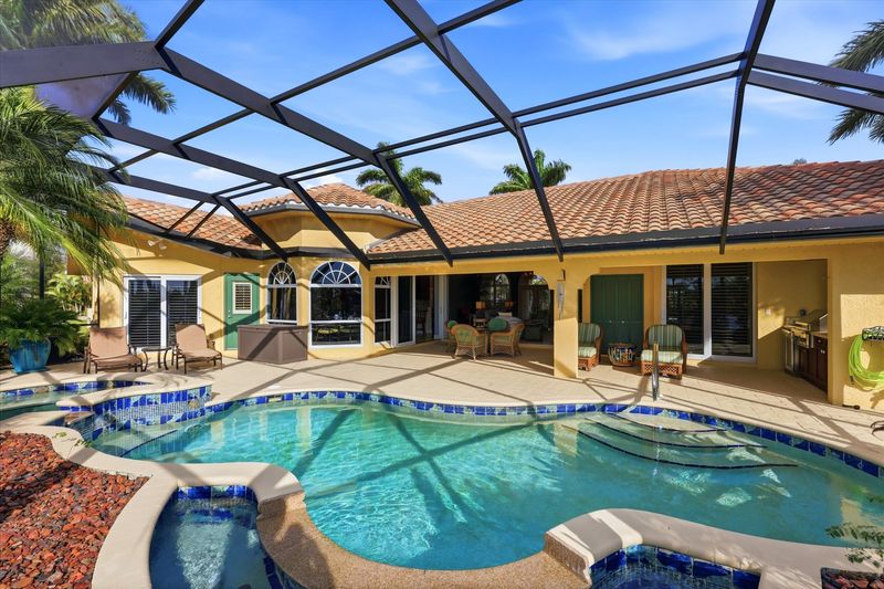 Large outdoor living space overlooking the sparkling pool & spa, and the canal beyond. Space also features out door furniture, a dining table that seats 4, outdoor kitchen with grill & fridge, ans sun loungers. Pool size: 28' x 8' x 6'D