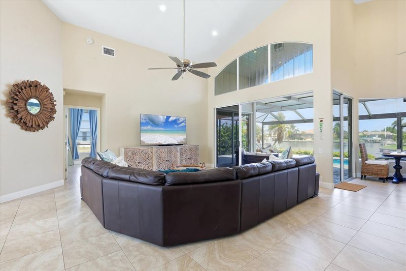 Family room with large sectional sofa, lanai access and 75-inch Smart TV